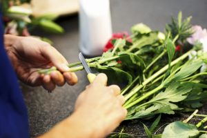 Female florist hands making bouquet in flower shop